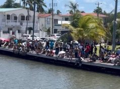 La Ruta Maya Belize River Challenge: Canoeing teams stage protest paddle to Belcan Bridge as large crowd gathers to welcome them